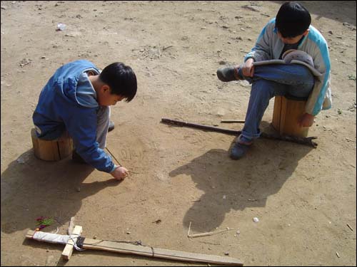 마당에서 한자쓰기 놀이하는 인효와 인상이. 